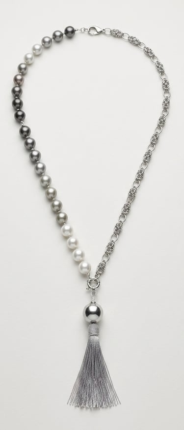 Elegant pearl and silver chain necklace featuring a gradient of grey pearls and a decorative silk tassel pendant.