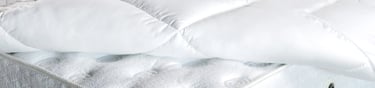 a mattress topper with a pillow and pillows