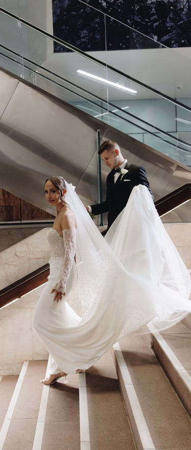 a bride and groom walking down a flight of stairs