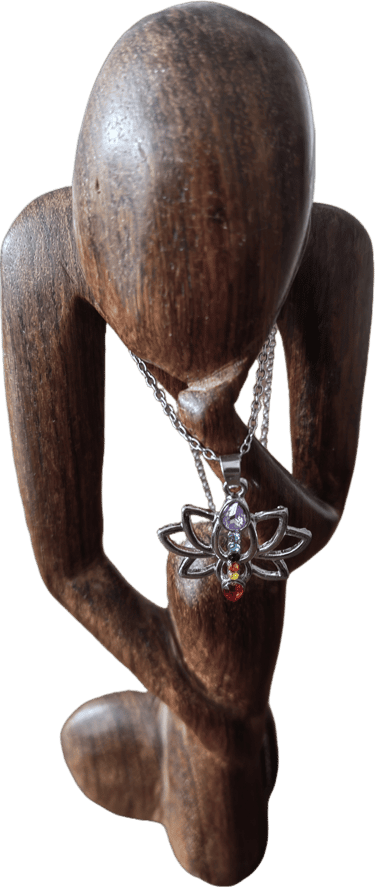a wooden sculpture of a woman holding a necklace with a butterfly
