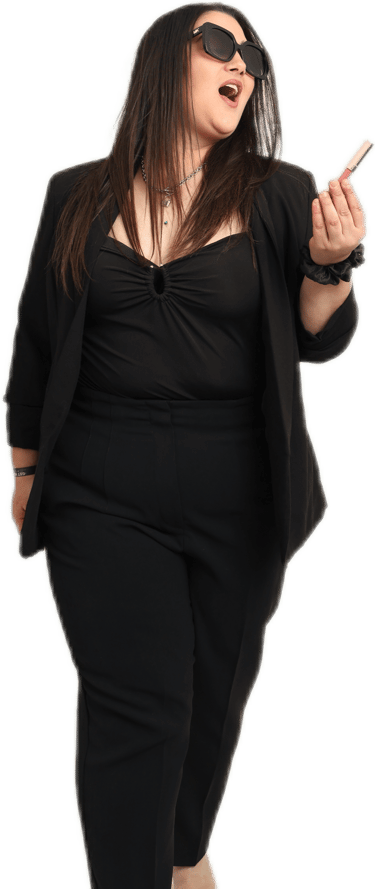 a woman in a black top and sunglasses with makeup in her hand