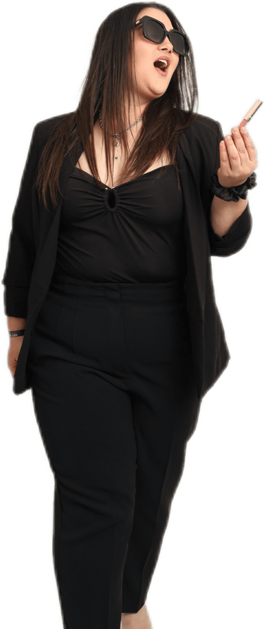 a woman in a black top and sunglasses with makeup in her hand