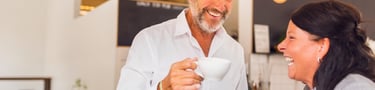 Two office colleagues drinking coffee and laughing