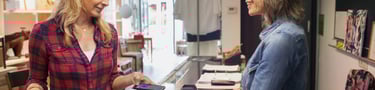 Women pays with her mobile in a shop, illustrating a good customer engagement