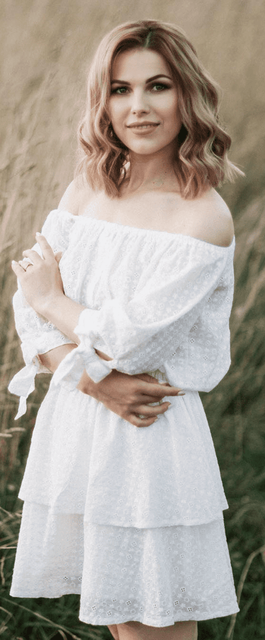 a woman in a white dress standing in a field