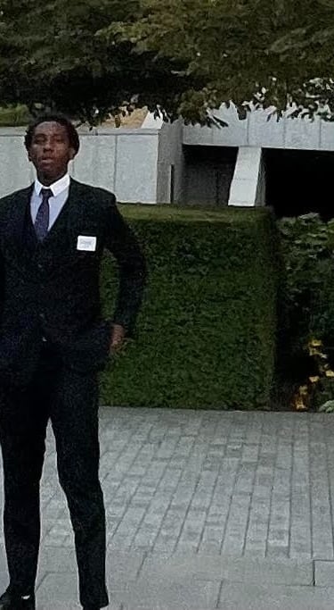 a man in a suit and tie standing in front of a building