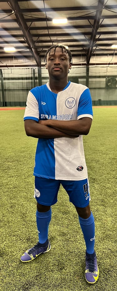 a man in a blue and white soccer uniform standing in a soccer field