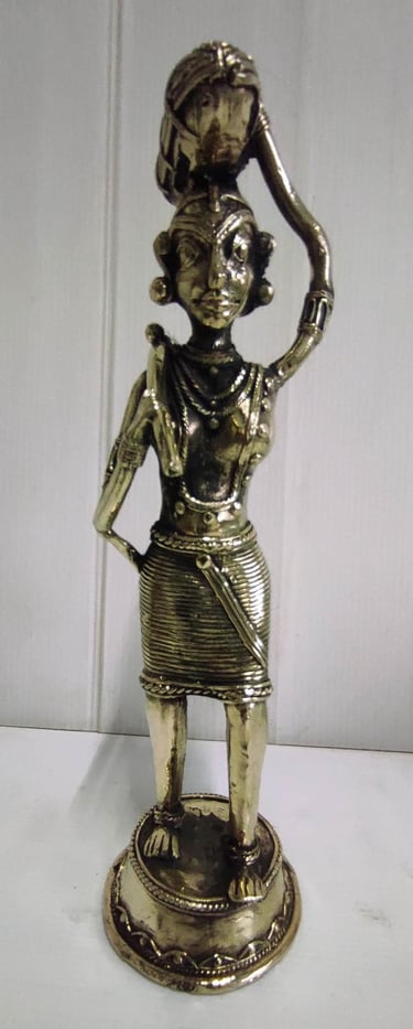 "Brass statue of a woman in attire carrying a pumpkin on her head and tools on her shoulder-For international dispatch
