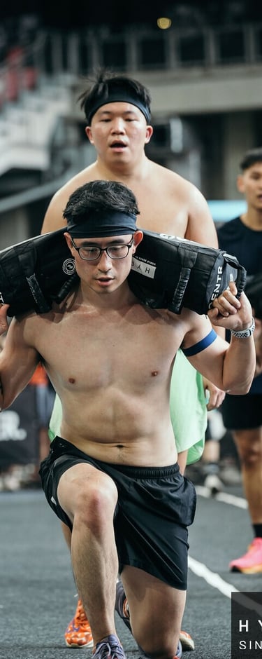 a man is carrying weighted bag during Hyrox