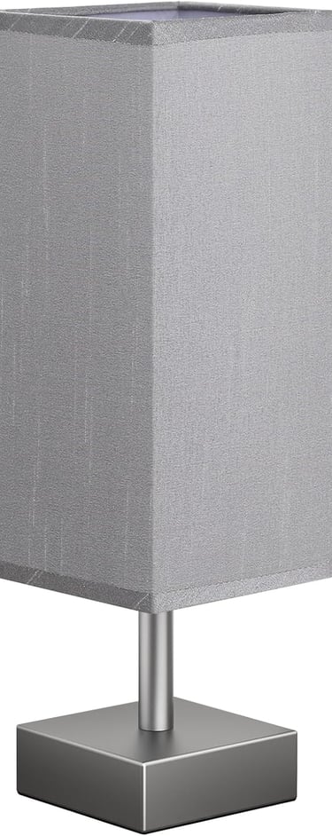 Modern square table lamp with grey fabric shade and silver metal base for bedroom or office lighting.