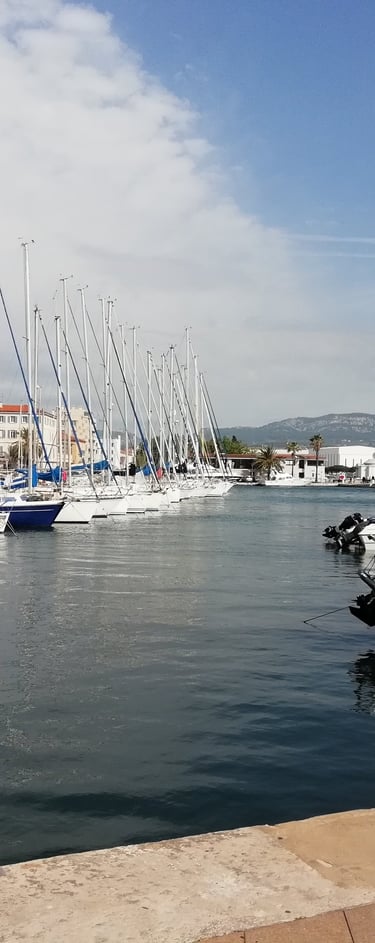 Port de la Seyne, Toulon, avec bateaux à voile amarrés et monts du toulonnais au fond