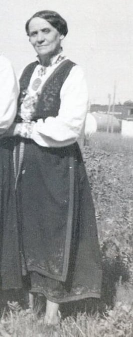 A black and white image of a woman in a bunad