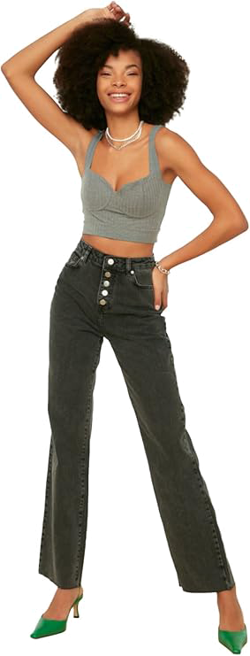 femme en jean debout bras sur la tete