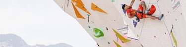 a man is lead climbing on a climbing wall