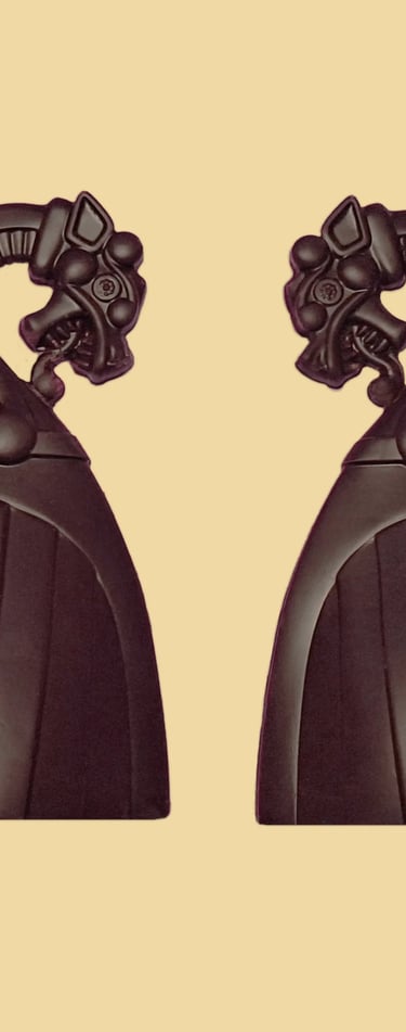 A pair of decorative black Viking ship dragon head in dark chocolate.