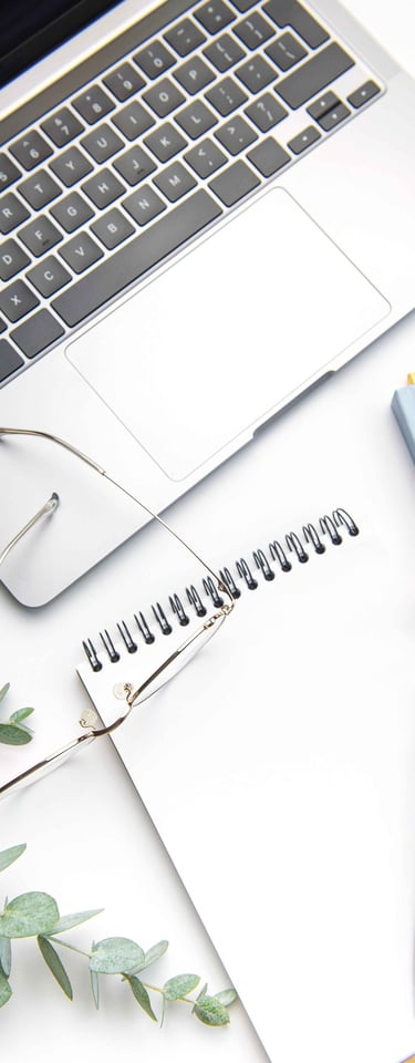 Image of a notebook with a laptop, glasses and eucalyptus leaves