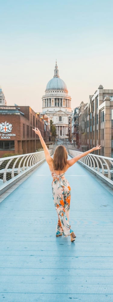 a woman in a floral dress walking across a bridge