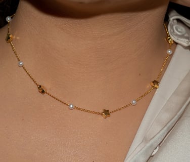 a woman wearing a white shirt and a gold necklace