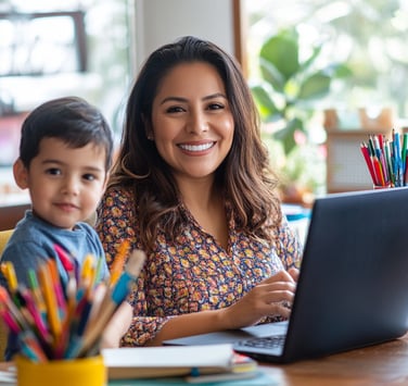 Mamá emprendedora sonriente con su hijo junto a la laptop, representa emprendimiento digital desde casa en familia..