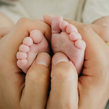 Pieds de bébé dans les mains de sa maman