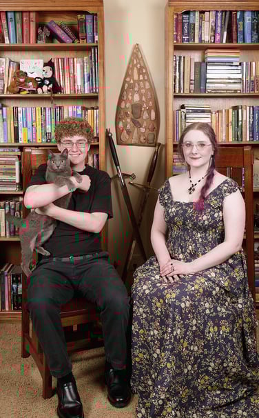 a son with a cat and a daughter sitting on a chair in a library