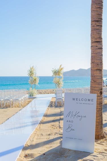 A beachside altar and empty chairs captured by Los Cabos Wedding Films at the Garza Blanca Hotel in San José del Cabo. Profes