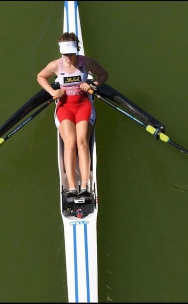 a woman rowing a boat on a lake