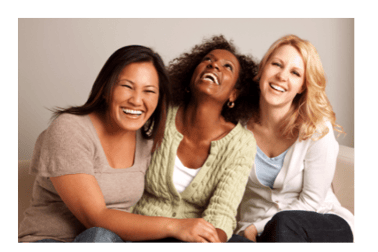 Three ethically diverse women sitting close together and laughing.