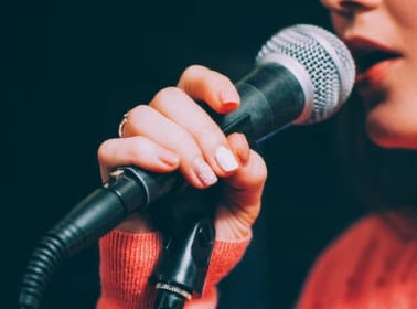 a woman in a red sweater and a microphone