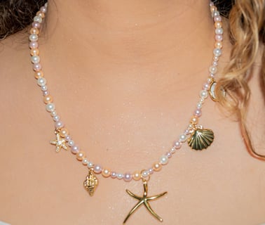 a woman wearing a white dress and a necklace with a starfish