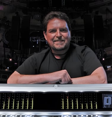 Jon Lemon smiling and leaning on mixing desk.