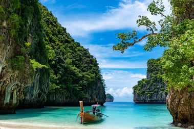 a boat in the water near a cliff