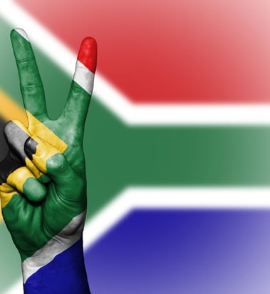 a person's hand holding up a peace sign