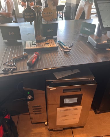  Nitro Cold Brew and Cold Brew tap system setup with tools on the counter at a coffee shop.