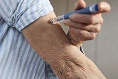 a man with a needled arm holding a pen