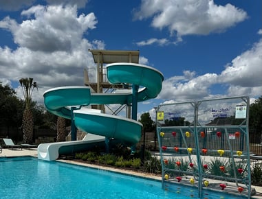 a water slide tower next to a pool