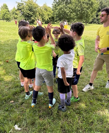 a group of children playing soccer in a field