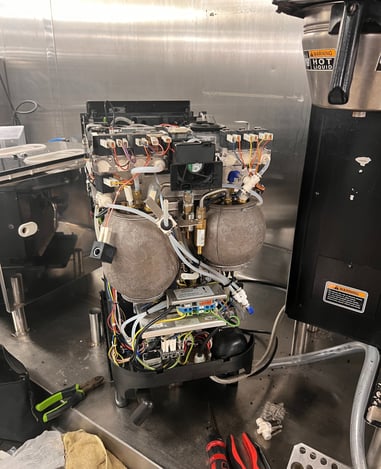 Super-automatic espresso machine opened for internal maintenance and repair in South Florida
