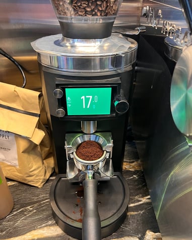 Precision coffee grinder dosing 17 grams of espresso directly into a portafilter.