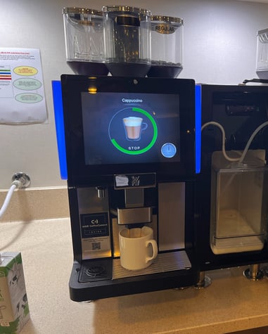 espresso machine setup preparing cappuccino with touchscreen interface.