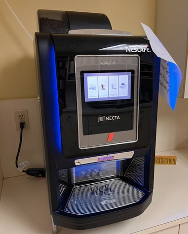 Nescafé Krea coffee vending machine with touchscreen interface.