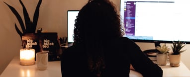 A picture of a girl wearing black and on her black desktop computer