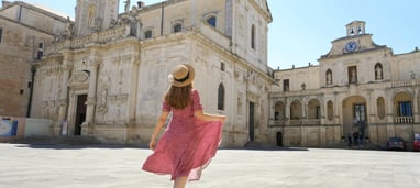 A girl dressed in pink walking in Lecce city center