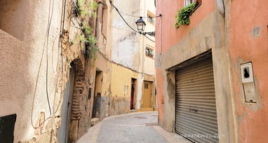 a beautiful winding medieval alley with colorful older houses in Espluga