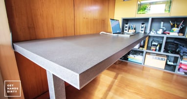 An almost floating working desk underneath a loft bed built with colored MDF.