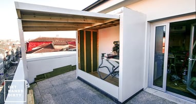 An outdoor shed in a small balcony. Grass over the roof.