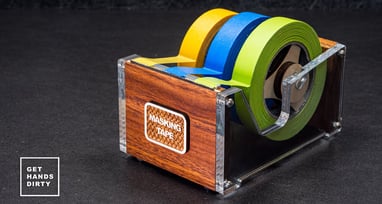 A multi roll tape dispenser made out of wood, acrylic and a bandsaw blade.