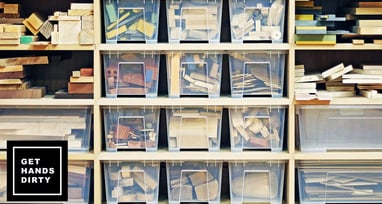 A storage wall storing a bunch of wood in different shelves and plastic boxes