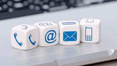 a laptop computer keyboard and a phone on a desk