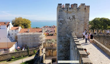 People walking on Saint George Castle walls located near Lisbon tram 28 stop